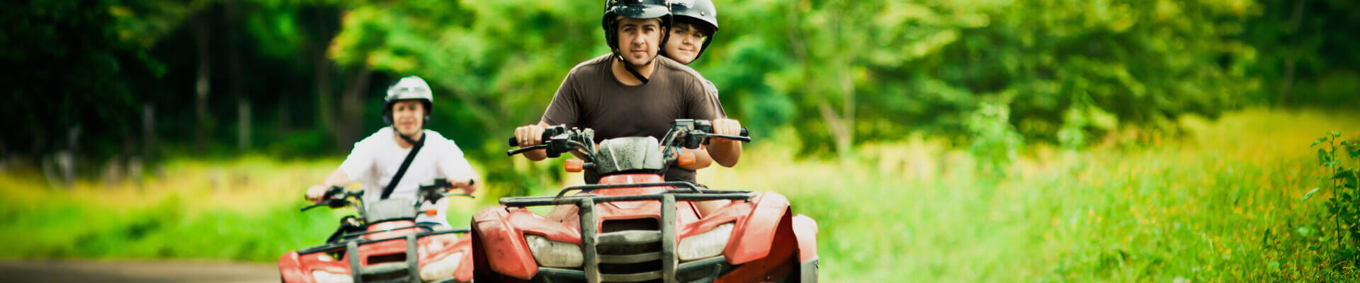 ATV Insurance Quote – Buy Off-Road Vehicle Insurance Man riding ATV with son sitting behind him and wife on ATV next to him