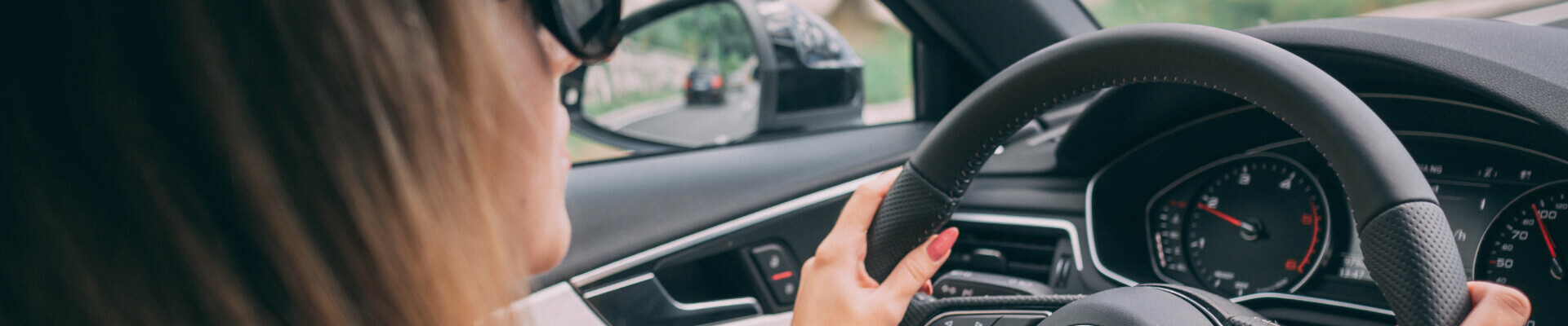 Auto Insurance Quotes – Get Affordable Auto Insurance Online Close up of woman wearing sunglasses with hands on the steering wheel of a car